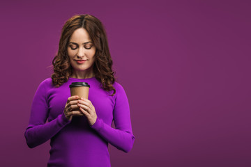 smiling girl holding coffee to go on purple background
