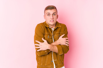 Young caucasian man isolated going cold due to low temperature or a sickness.