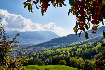 Mountains and a view from the height of the valley with houses at the bottom of a Sunny summer day - obrazy, fototapety, plakaty