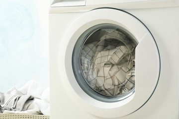 Laundry in a washing machine and in basket, close up