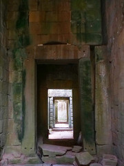 Fototapeta na wymiar Demolished stone rock door frame at Preah Khan temple Angkor Wat complex, Siem Reap Cambodia. A popular tourist attraction nestled among rainforest.