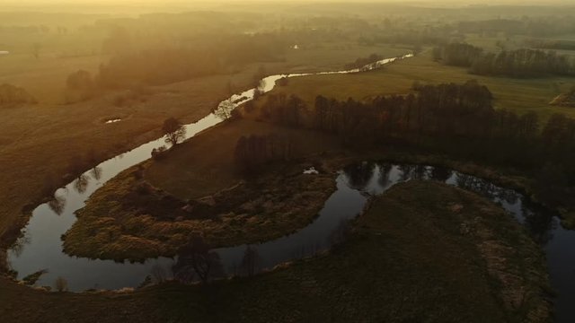 Scenic video of Polish river Wkra at sunset, almost fantasy scenery. Drone, aerial shot. Cinematic grading.