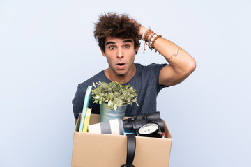 Man making a move while picking up a box full of things with surprise facial expression