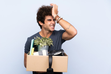 Man making a move while picking up a box full of things having doubts with confuse face expression
