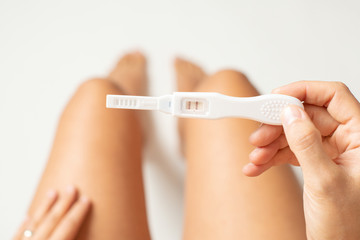 Top view of a woman holdin pregnancy test. Isolated on white