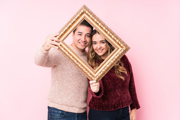 Fototapeta premium Young latin couple holding a frame