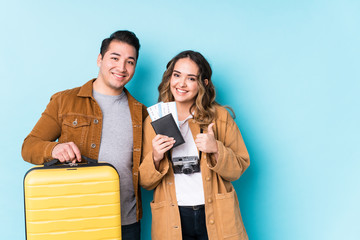 Young couple ready for a travel isolated smiling and raising thumb up