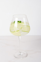 water with ice, lime and cucumber on a white background