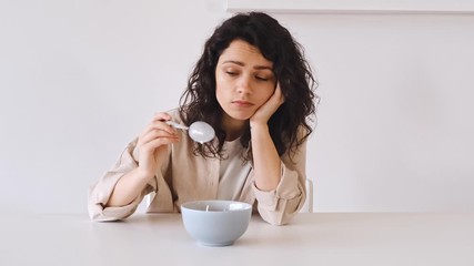 The young woman lost her appetite, apathy, and depression. A woman does not want to eat her food. Bad mood and not tasty food