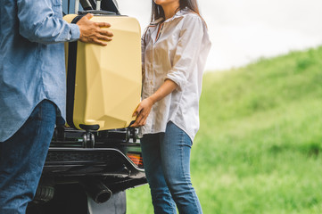 Asian man helping woman to lifting suitcase from car during travel in long weekend. Couple have...