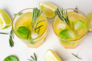 drink with lime ice and rosemary in a glass on a white background