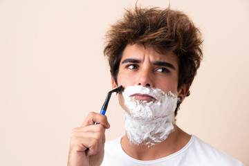Young handsome man shaving his beard