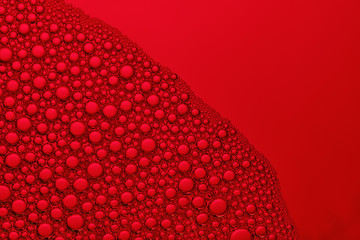 Abstract red background with soap bubbles in the water. Foam in high magnification. Macro. Close-up.