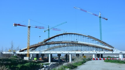 Gran puente en construcción para una autopista, con andamios y gruas