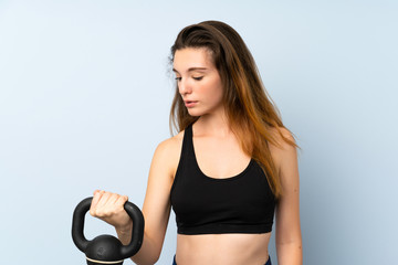 Fototapeta na wymiar Young brunette girl making weightlifting with kettlebell over isolated background