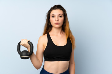 Fototapeta na wymiar Young brunette girl making weightlifting with kettlebell over isolated background