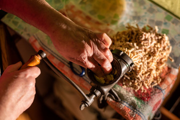  Mincing meat with an old manual mincer to fill cannelloni, typical gastornomy of Catalonia