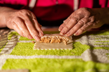 Rolling cannelloni with minced meat in a traditional way, typical gastronomy of Catalonia.