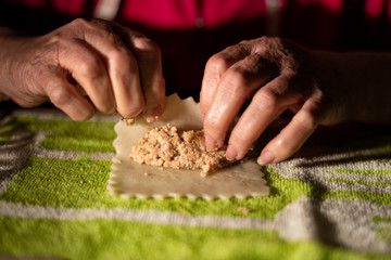 Rolling cannelloni with minced meat in a traditional way, typical gastronomy of Catalonia.