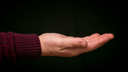 Stretched male hand on black isolated background_