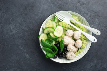 Keto paleo diet lunch, mashed broccoli with butter, meat balls in sour cream sauce, spinach, cucumber, olives. Low carbohydrate. High fats, a lot of fiber. Top view,