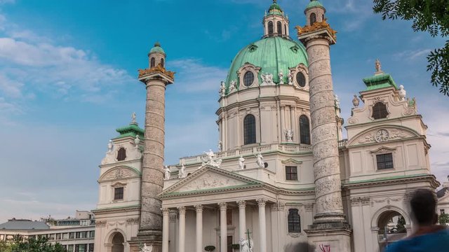 Karlskirche on the Karlsplatz square timelapse in Vienna, Austria. People walking and sitting at fountain. It is a catholic church, also called Rektoratskirche, with a typical baroque architecture.