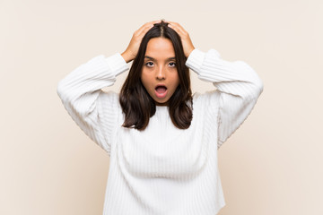 Young brunette woman with white sweater over isolated background with surprise facial expression