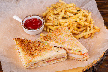 Sandwiches with chicken and vegetables, served with fries and ketchup potatoes