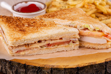 Chicken clab sandwich, served with ketchup and fries