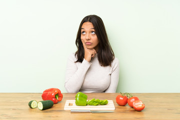 Young brunette woman with vegetables thinking an idea