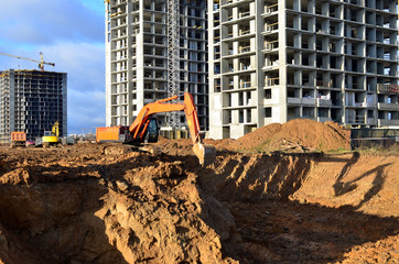 Excavators and dozers digs the ground for the foundation and construction of a new building. ...