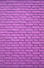Fototapeta na wymiar Vertical Image of Purple Pink Colored Aging Brick Wall