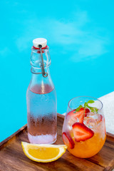 orange italian soda with fresh strawberry on pool side