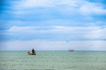 a fisherman rowing his boat in open sea
