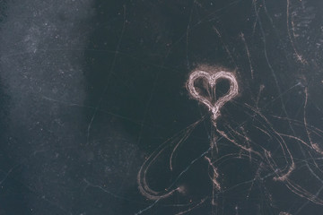 Heart drawn skates on ice, for a loved one. Unrequited love. Frozen heart. Top view.