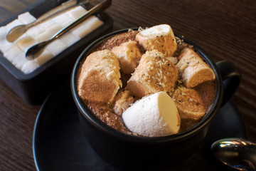 Hot cocoa with mini marshmallows on wooden board
