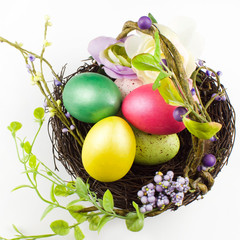 happy Easter, colored eggs in a basket and spring flowers on a white background, spring Orthodox Christian and Catholic holiday, banner with space for text
