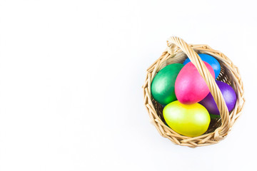 happy Easter, colored eggs in a basket and spring flowers on a white background, spring Orthodox Christian and Catholic holiday, banner with space for text
