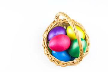 happy Easter, colored eggs in a basket and spring flowers on a white background, spring Orthodox Christian and Catholic holiday, banner with space for text