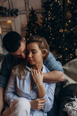 A guy with a girl is celebrating Christmas. A loving couple enjoys each other on New Year's Eve in a cozy home environment. New Year's love story.