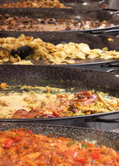 Hot pans with steaming food served in a local food festival - 314329095