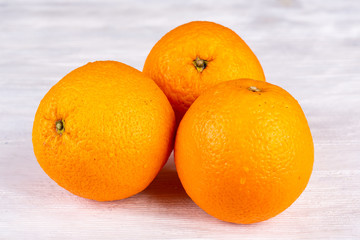 Oranges three pieces on a white wooden background