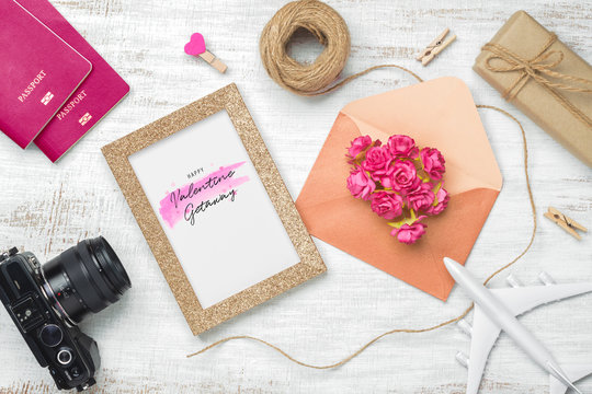 Mockup golden picture frame for travel with valentines day & love season background concept. Top view of mock up photo frame with rose flowers, craft roses, passport, camera, airplane model