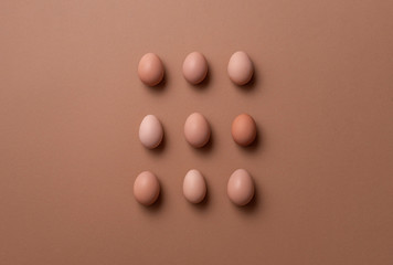 Organic eggs on brown background. Brown eggs in symmetry display