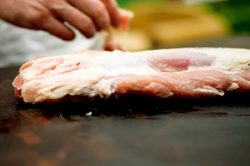 Cutting piece of pork meat on the table. Raw pork.