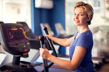 Naklejka premium Woman training in cardio zone in the gym. People, fitness and health concept