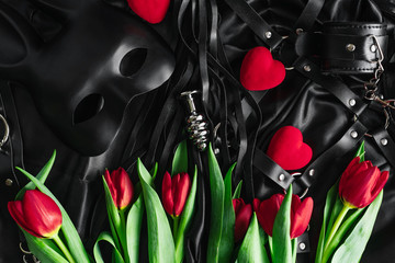 Explore the world of kinky play. Top view of bdsm leather kit (whips, handcuffs, mask and chain)...