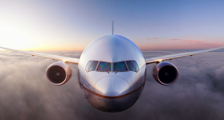 Airplane flying above the clouds during colorful sunset or sunrise. Concept of Travel, transportation, aviation, journey, adventure © edb3_16