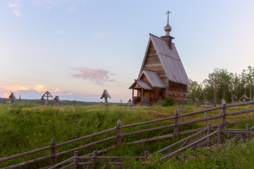 An old wooden Church stands on top of a hill. The Church is illuminated by the rays of the setting sun. Ples, Ivanovo Region, Russia.