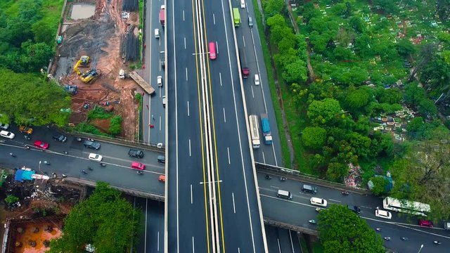 BEKASI, WESTJAVA, INDONESIA : JANUARY 10 202 : Aerial drone view of highway multilevel junction road with moving cars after rainy. Cars are moving on a road junction